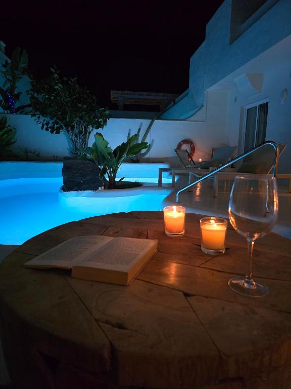 a wooden table with two candles and a wine glass at Natural Renacer Zen Baby Package Included in Corralejo