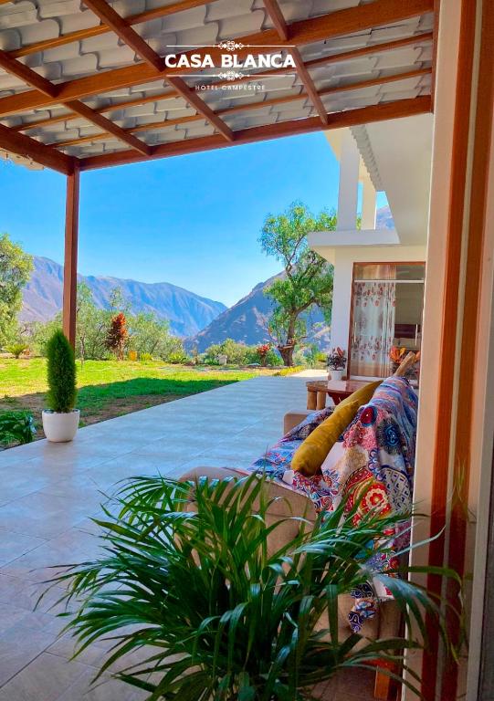 a couch on a patio with a view of mountains at HOTEL HUAYTARA CasaBlanca in Huaytará