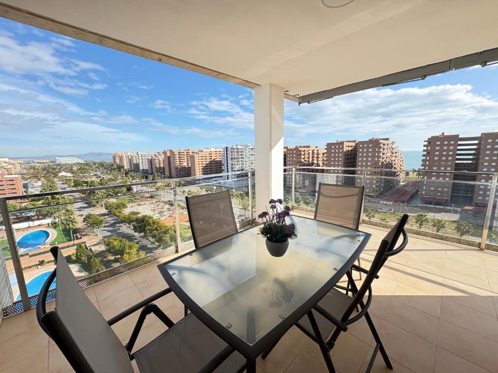 a glass table and chairs on a balcony with a view at ACV- Terrazas II-2ª linea planta 9 este in El Borseral