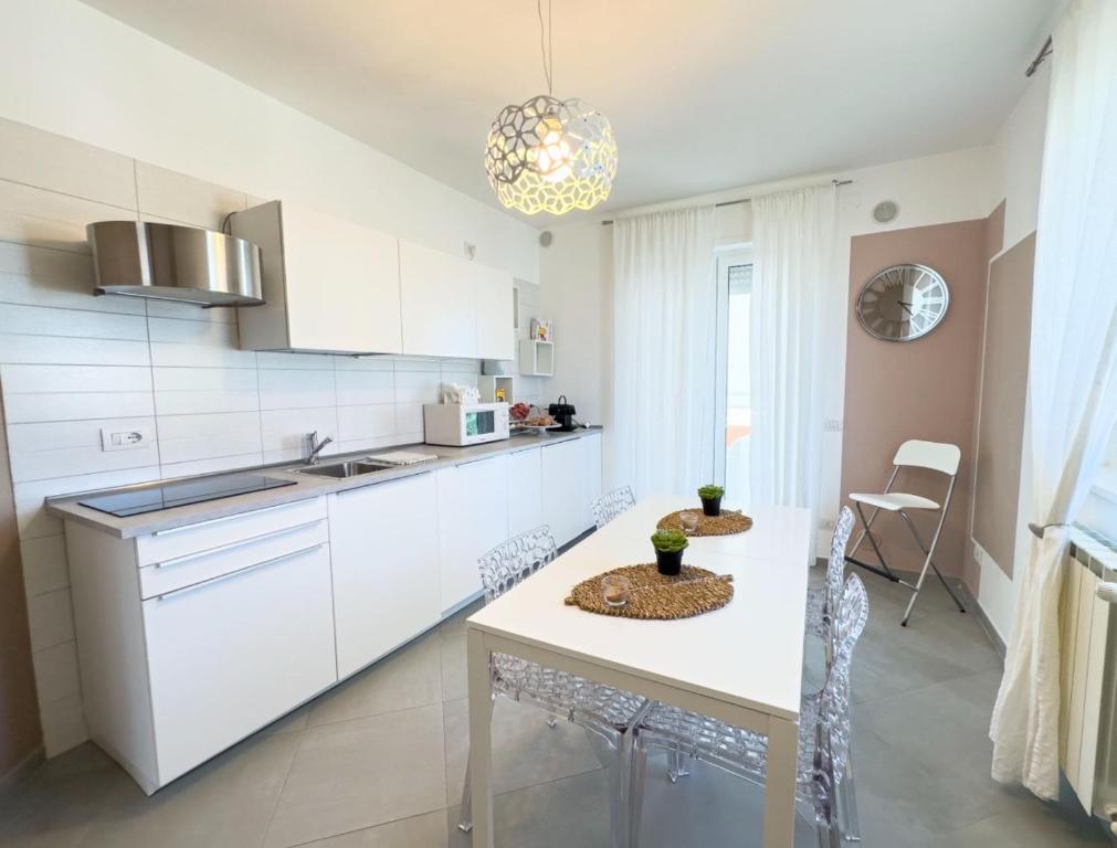 una cucina con mobili bianchi e tavolo di B&B ALLA NIVIERA ad Adelfia