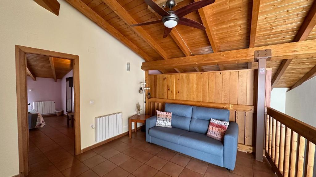 ein Wohnzimmer mit einem Deckenventilator und einem blauen Sofa in der Unterkunft Casa Rural Hoces del Cabriel in Villargordo del Cabriel