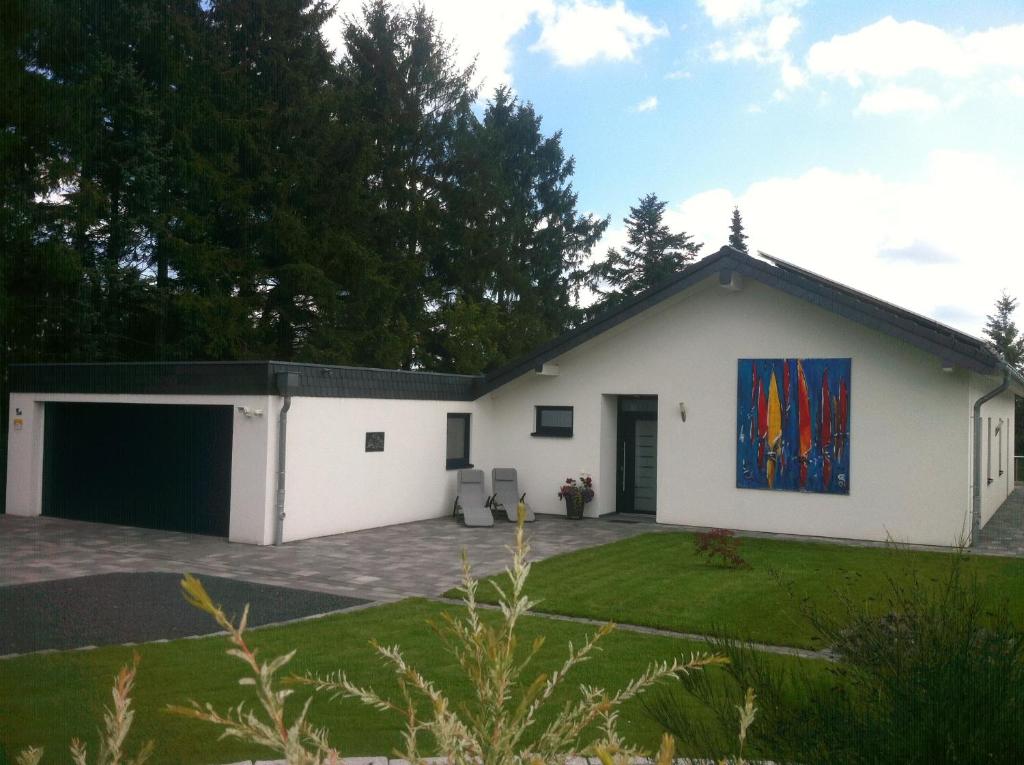 ein weißes Haus mit einem Gemälde an der Wand in der Unterkunft Ferienhaus Eschauel in Nideggen