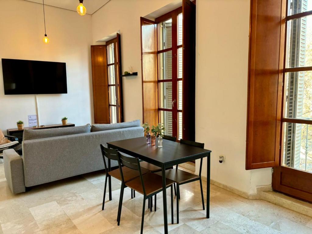 un soggiorno con un tavolo e un divano di Apartamento insonorizado con vistas a plaza Bib Rambla a Granada