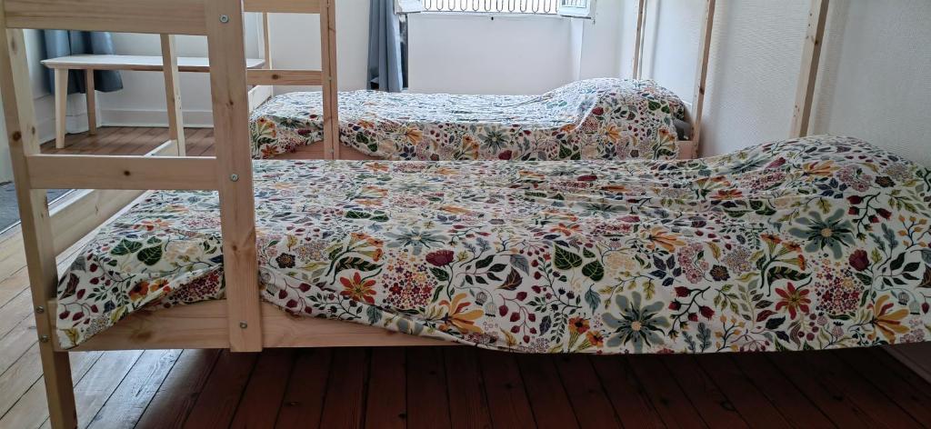- un lit avec une couette en fleurs assise sur un lit superposé dans l'établissement Bed in 6-beds Women Dormitory Le Jardin Cafe, à Bordeaux