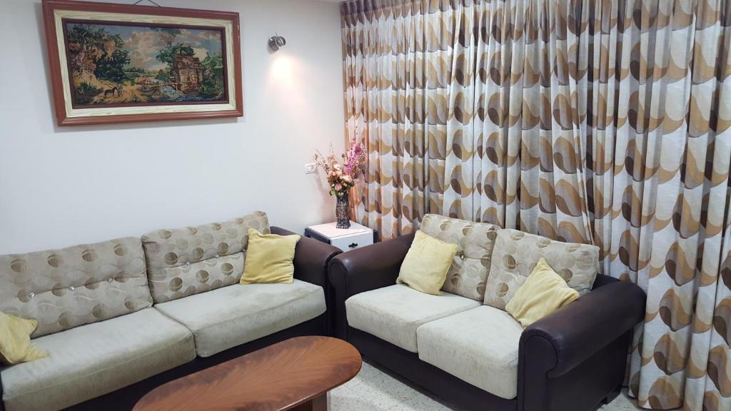 a living room with two couches and a table at Zohar's Apartment in Haifa