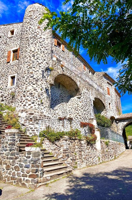 - un bâtiment en pierre avec des escaliers devant dans l'établissement Gîte lePigeonnier - Ardèche, à Aubignas