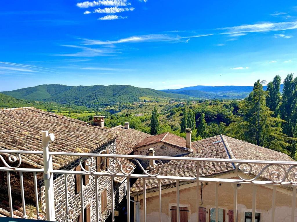 a view of a house with mountains in the background at Gîte lePigeonnier - Ardèche in Aubignas