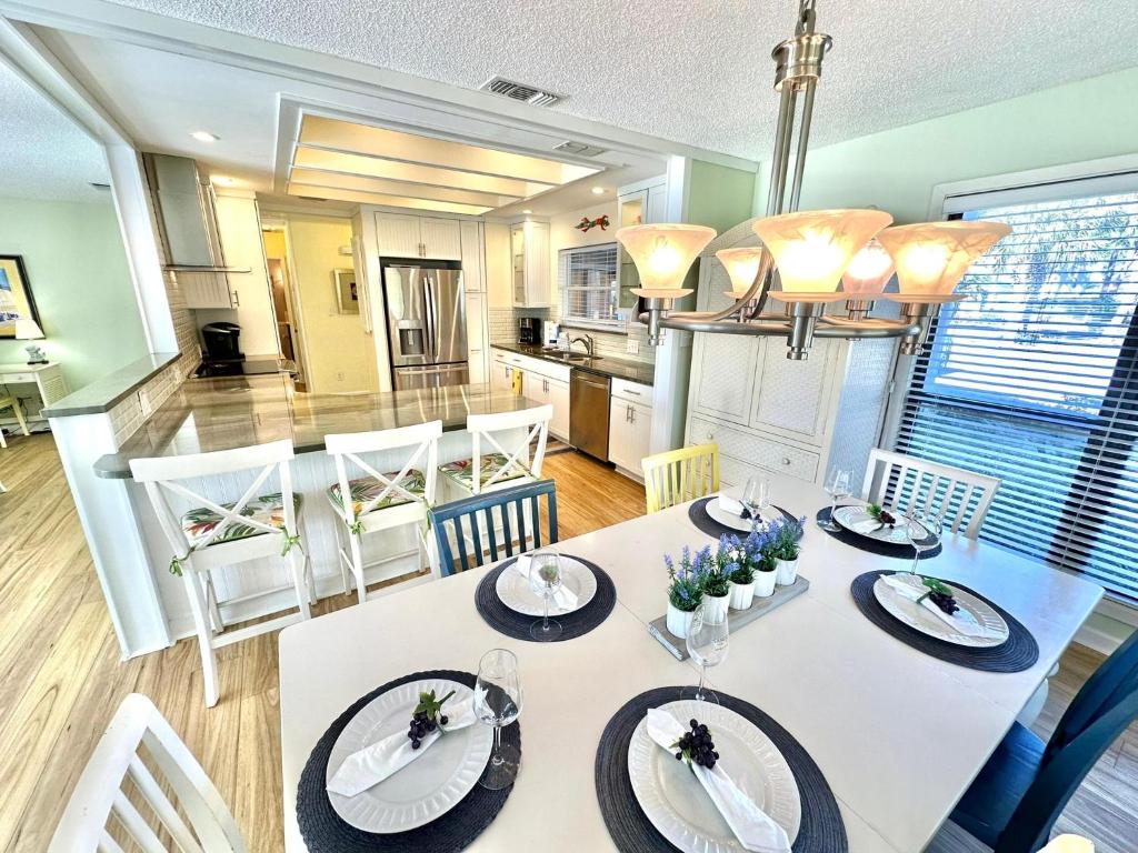a dining room and kitchen with a white table and chairs at 750 Sandpiper in Destin