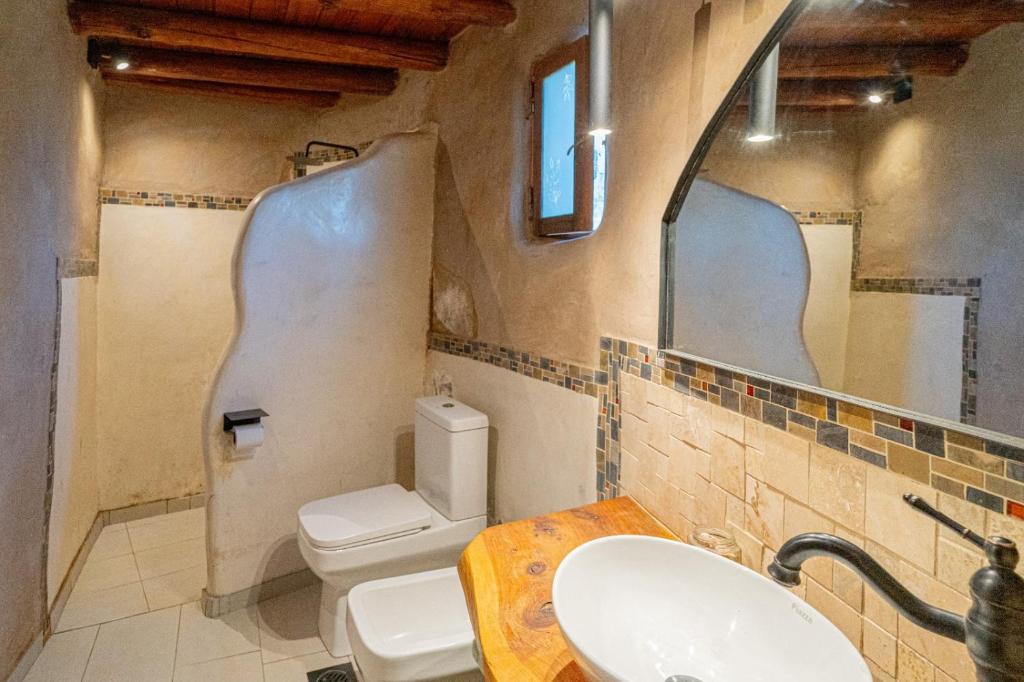 a bathroom with a toilet and a sink and a mirror at Terracota Eco-Casa Intiyaco 6 Pax in Atos Pampa