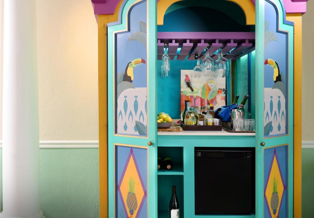 a colorful cabinet in a room with a bottle of wine at Ocean Key Resort & Spa, a Noble House Resort in Key West
