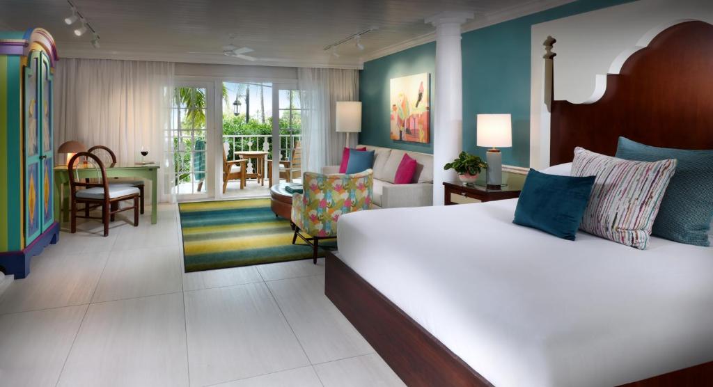 a bedroom with a large bed and a living room at Ocean Key Resort & Spa, a Noble House Resort in Key West