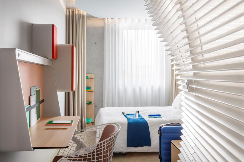 um quarto com uma cama, uma mesa e cadeiras em Okko Hotels Cannes Centre em Cannes