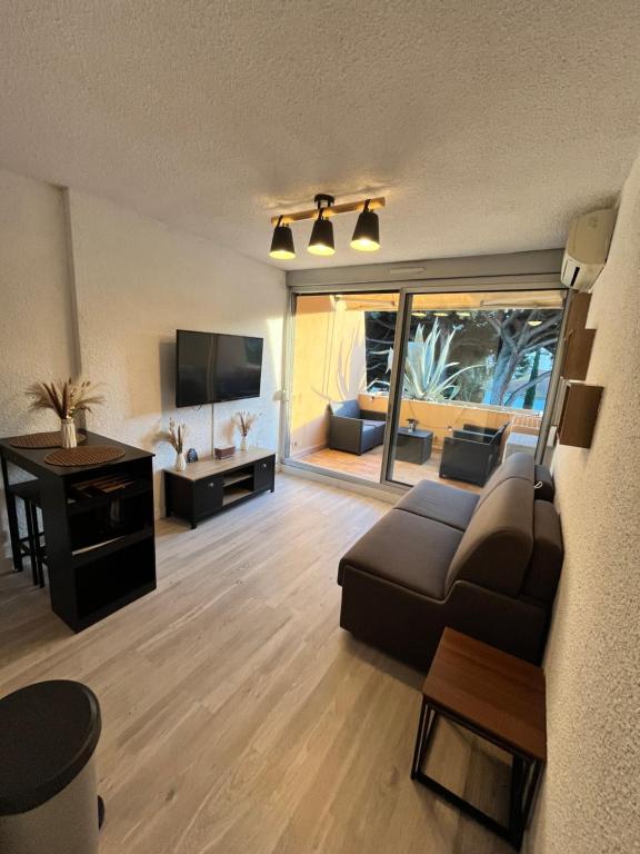 un salon avec un canapé et une télévision dans l'établissement Cocon Azur Studio Cavalaire, à Cavalaire-sur-Mer