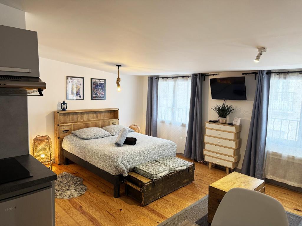 a bedroom with a bed and a dresser and a television at Le "Duo Sètois" in Sète