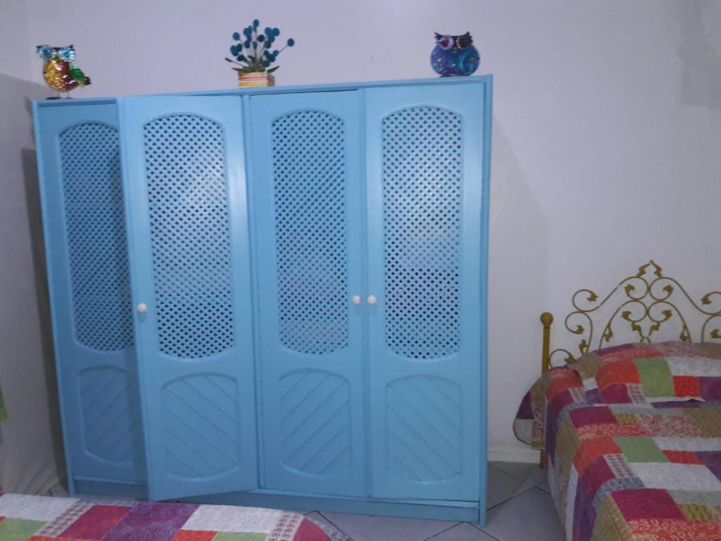 einen blauen Schrank in einem Schlafzimmer mit einem Bett in der Unterkunft Casa mobiliada tipo chácara para cop30 in Benfica