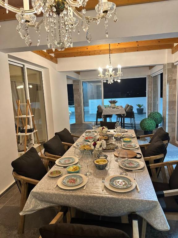 a dining room with a long table with dishes on it at Sea View Penthouse in Larnaca