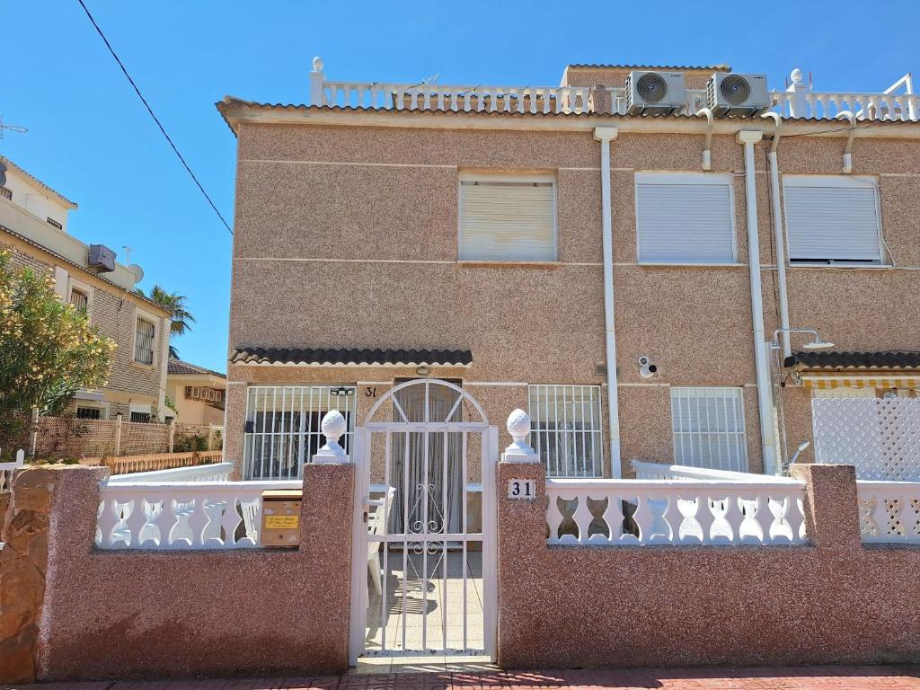 a brick building with a gate in front of it at Casa La Mata in Torrevieja