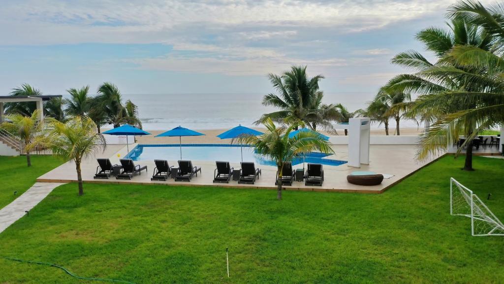 een zwembad met stoelen en parasols en de oceaan bij Hidden Paradise Club in Acapulco