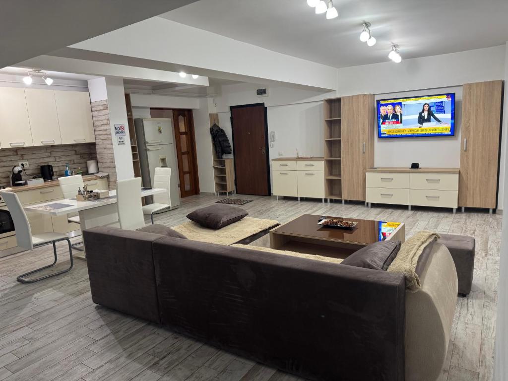 sala de estar amplia con sofá y TV de pantalla plana. en Apartament 3 camere lux cu terasă - Central Universitatea din Craiova - PARCARE GRATUITĂ, en Craiova