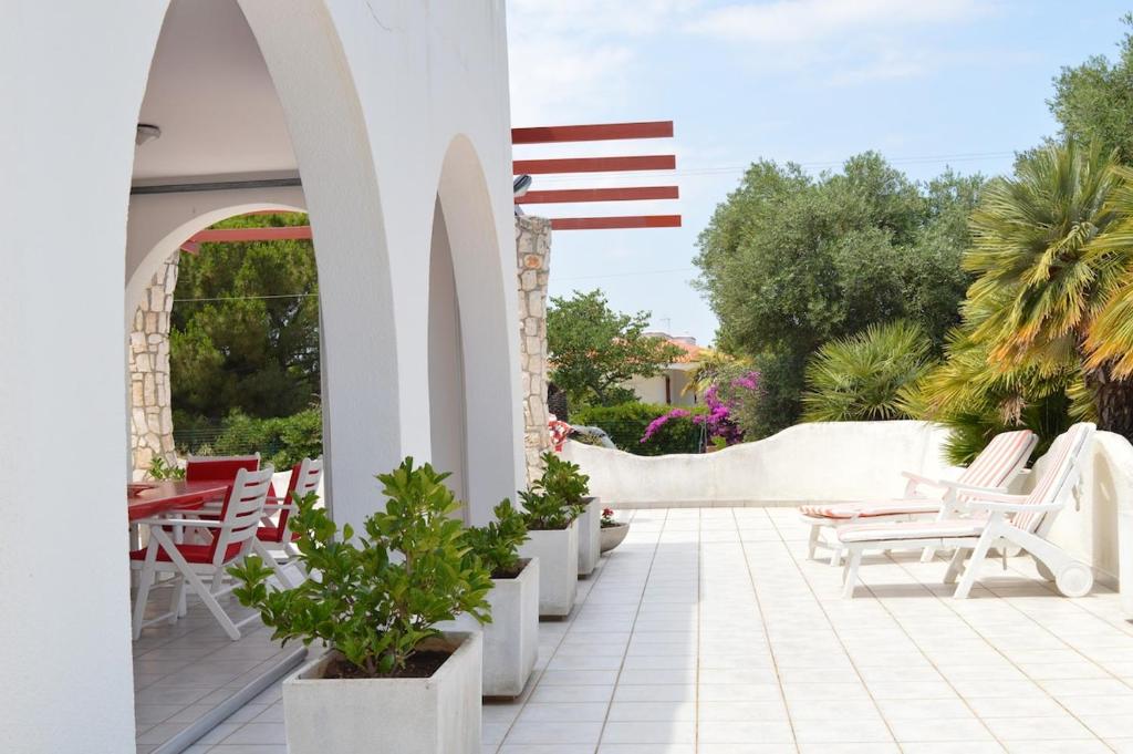 an outdoor patio with chairs and an american flag at Villa Adele Monopoli,Puglia in Faccia di Trippa