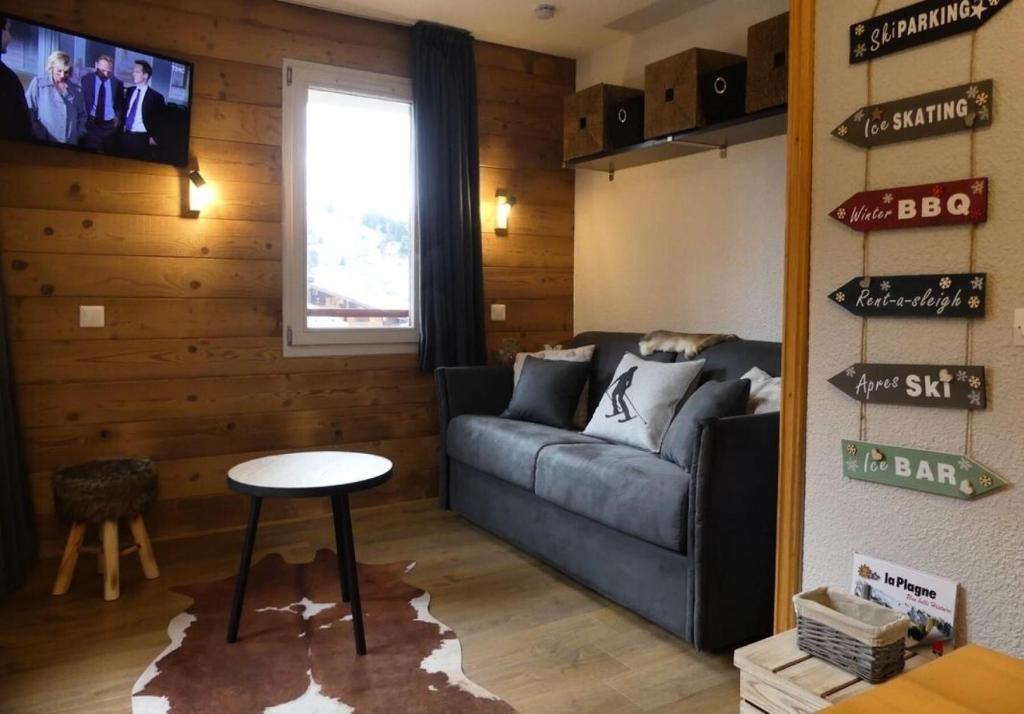 un salon avec un canapé et une table dans l'établissement Résidence Les Chalets des Arolles - maeva Home - Charmant studio 4 personnes - Confort - Sélection MAE-9741, à Aime La Plagne