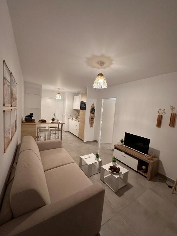 Il comprend un grand salon avec un canapé et une cuisine. dans l'établissement A 500m de la plage - L Oyat -, à Mimizan-Plage
