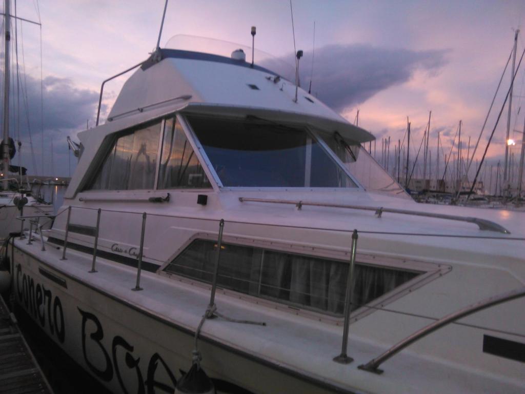 a white boat is docked in a harbor at Conero Boat&breakfast in Ancona