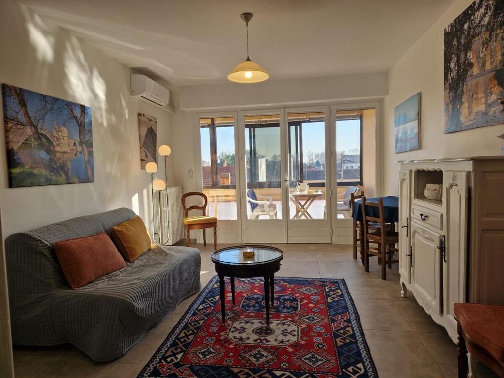 un soggiorno con un divano e un tavolo di T2 avec grand balcon filant, Wifi, Clim à 4 min Remparts ad Avignone