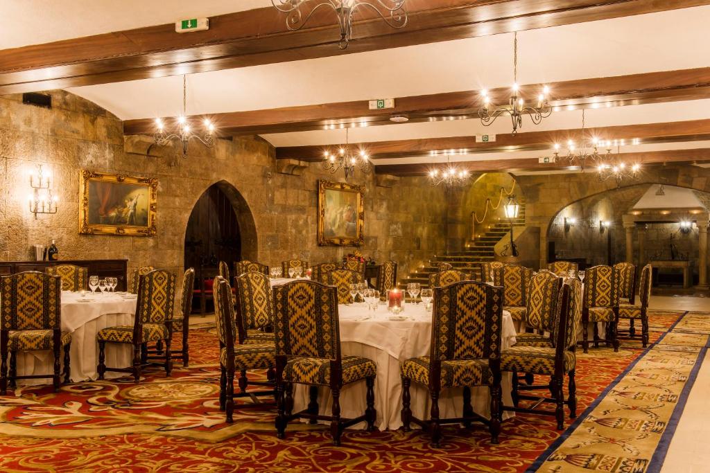 a dining room with tables and chairs in it at Hotel Fortaleza do Guincho Relais & Châteaux in Cascais