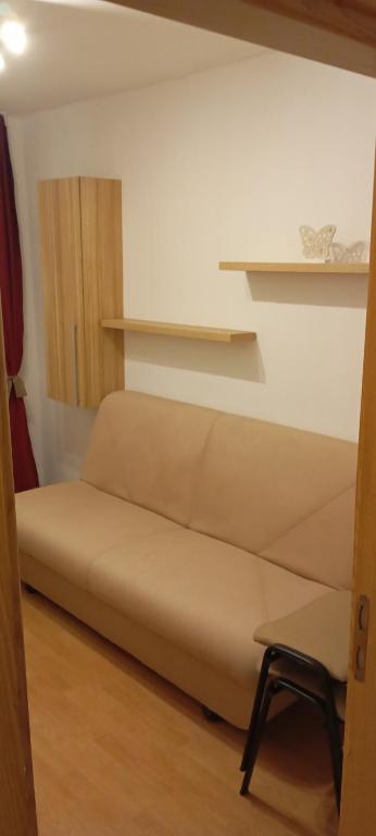 a couch in a room with shelves and a chair at Apartament vacanta in Sibiu