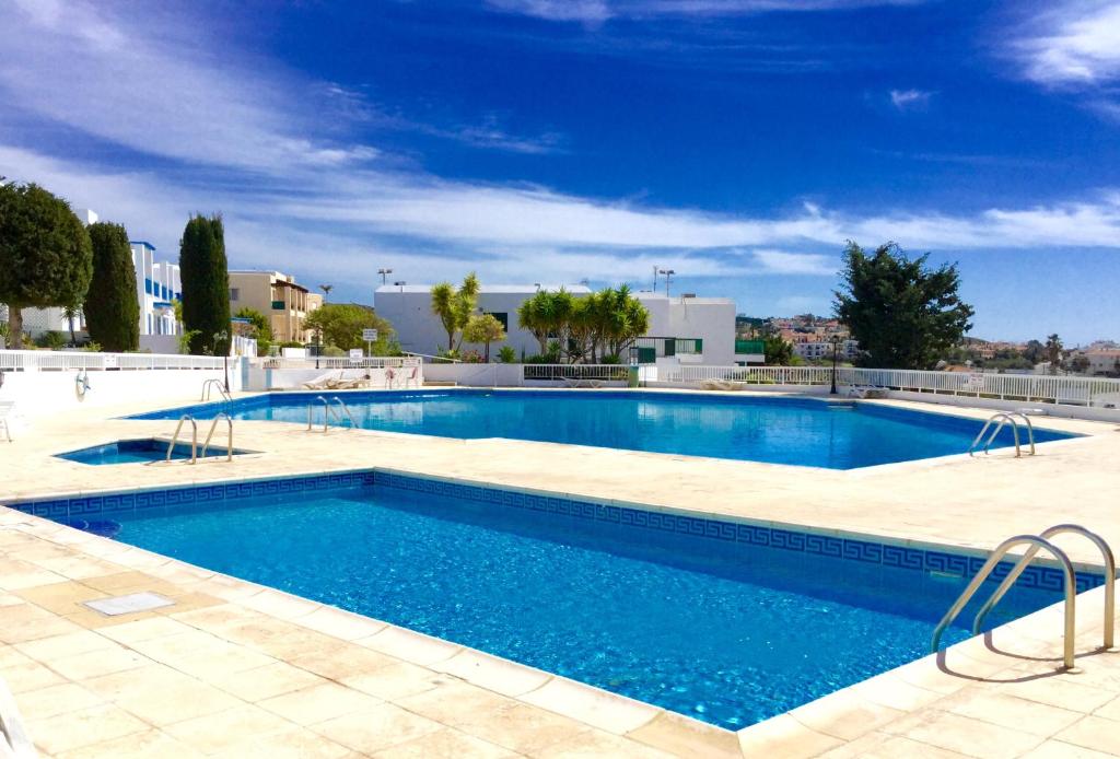 a large swimming pool with blue water at Ikaria Village Studio in Paphos