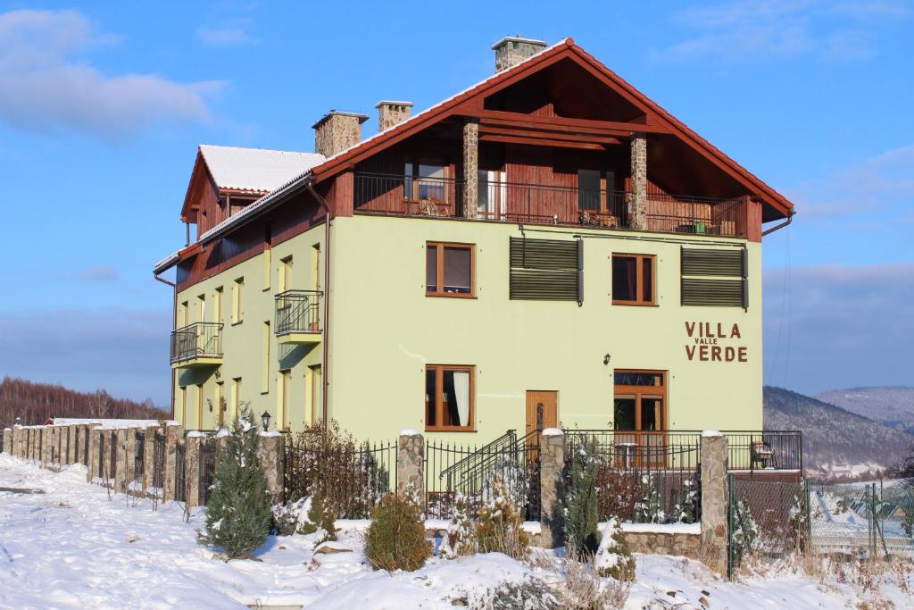 a house in the snow with a fence at Villa Valle Verde in Stronie Śląskie