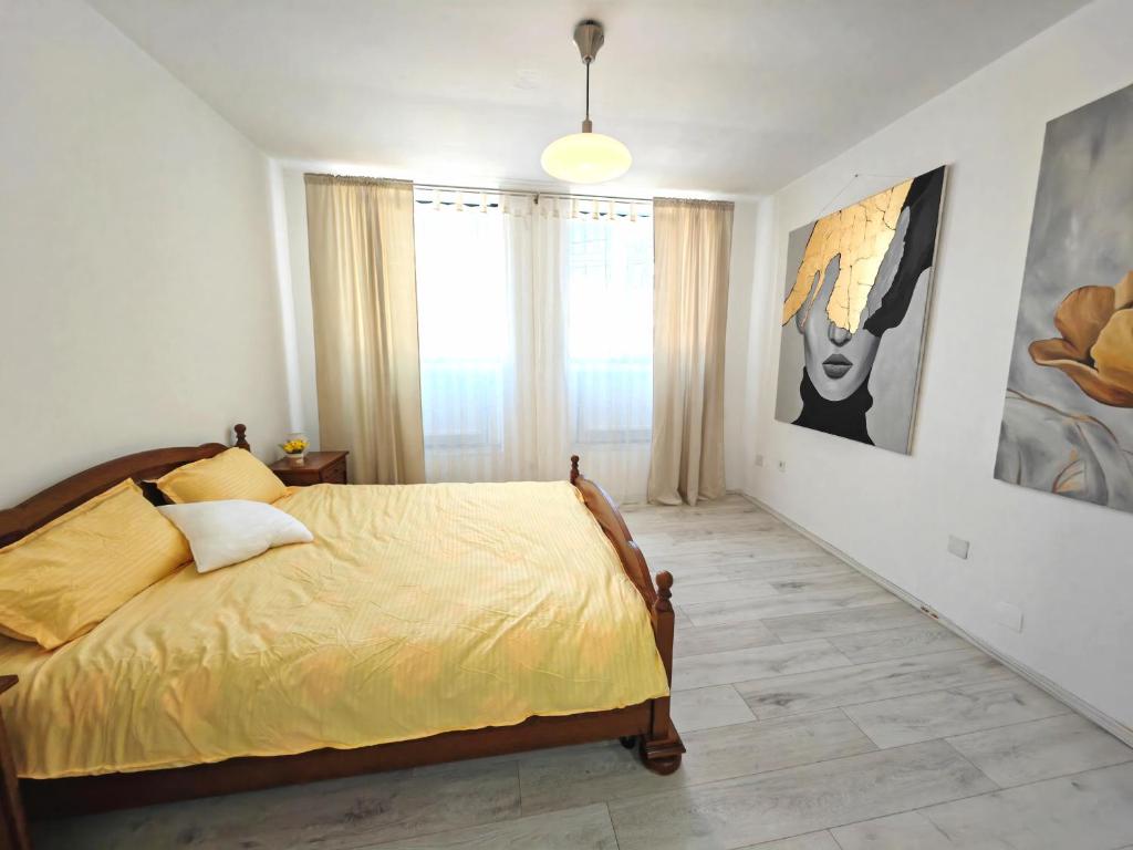 een slaapkamer met een bed met een gele sprei bij Central Apartments Madona in Craiova