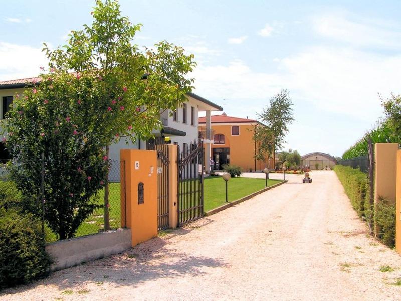 eine unbefestigte Straße mit einem Zaun vor einem Haus in der Unterkunft Agriturismo Il Melograno in Tessera