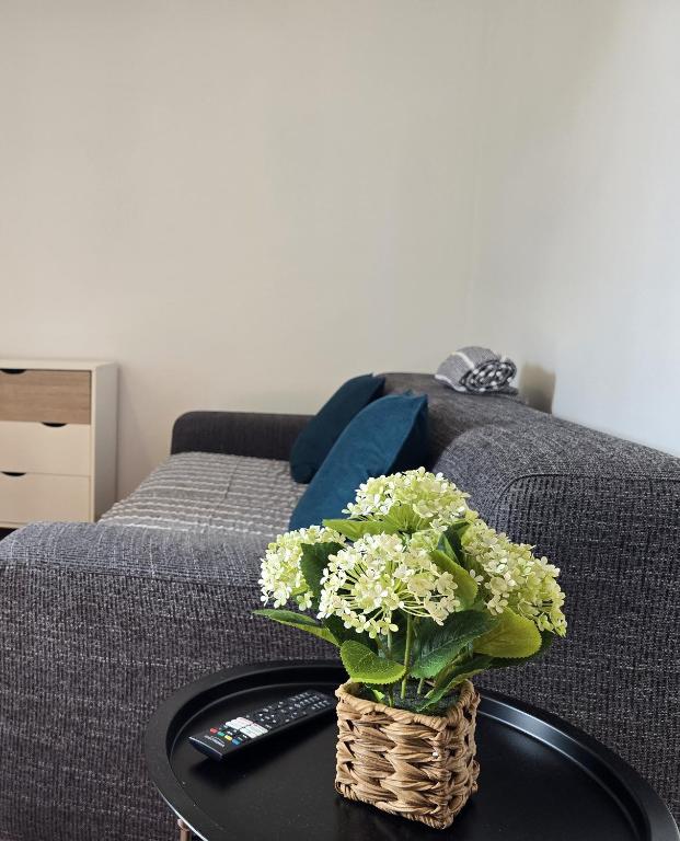 a vase of flowers on a table next to a bed at Autonomia House IV in Câmara de Lobos