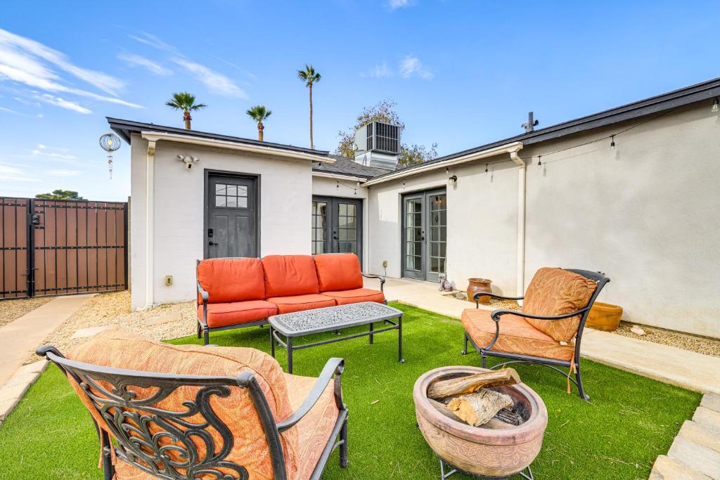 a backyard with a couch and chairs on the grass at 1 Mi to Grand Ave Modern Home with Spacious Yard! in Phoenix