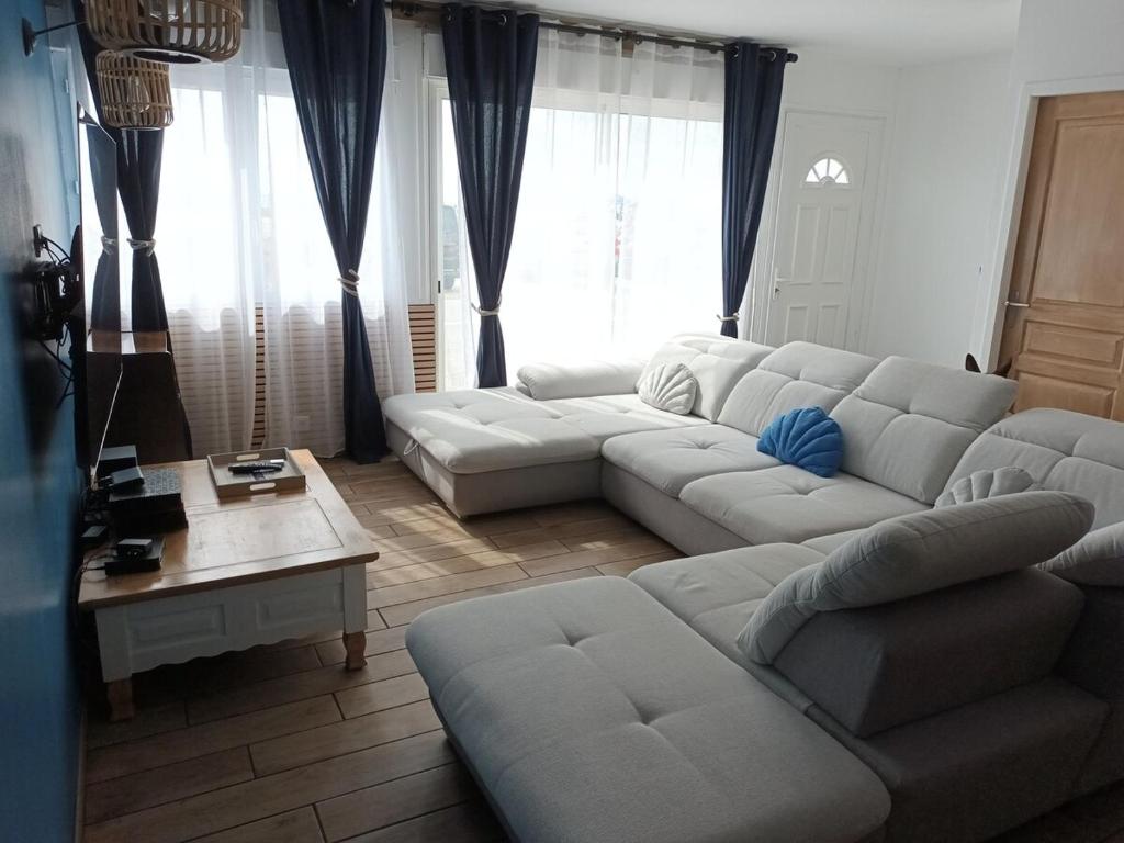 un salon avec un canapé blanc et une table dans l'établissement Maison face à l'océan classé 3 étoiles, à Montalivet-les-Bains