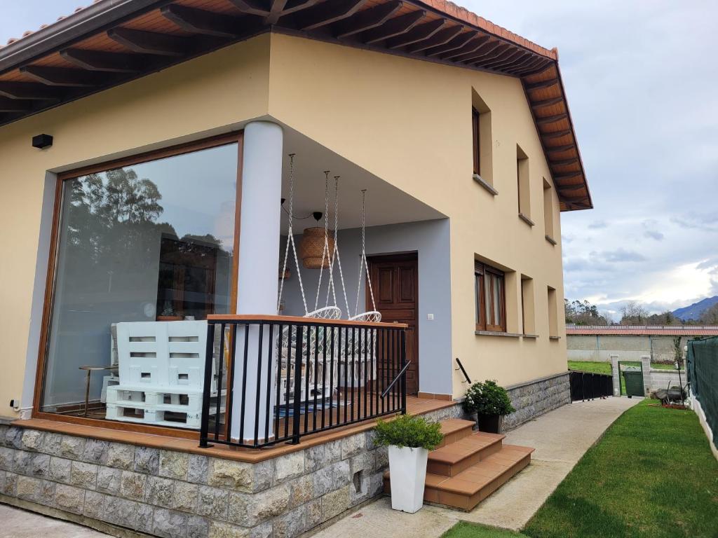 a house with a large glass window on a balcony at Villa chloé Spa in Llanes