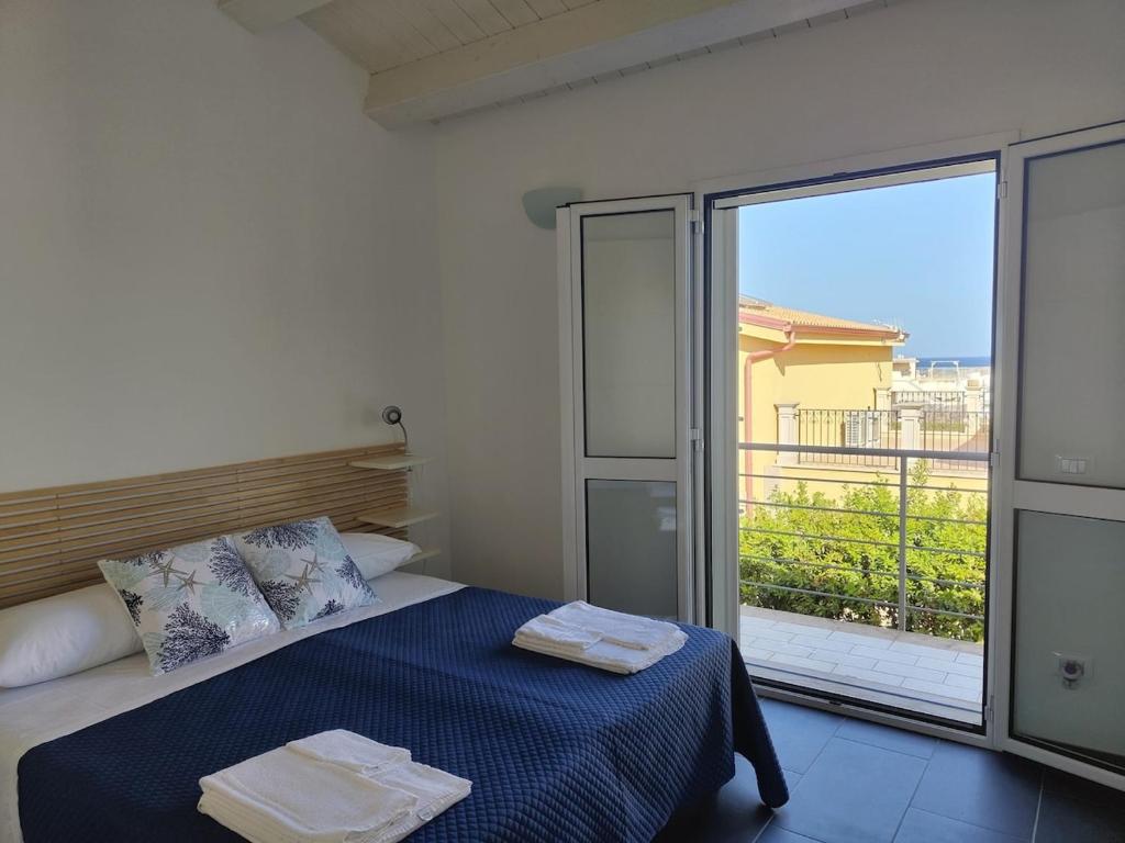 una camera con un letto e una grande porta scorrevole in vetro di Brezza di Levante a Calabernardo
