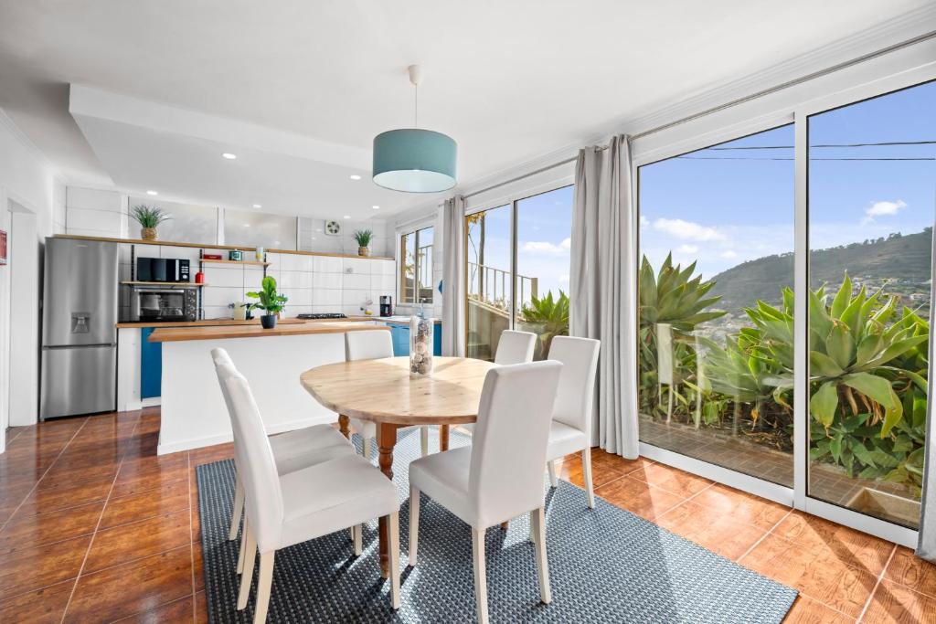 una cucina e una sala da pranzo con tavolo e sedie di Petit Campanário a Campanário