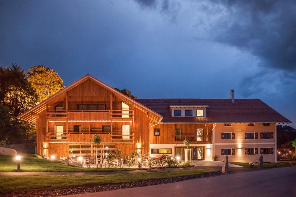 ein großes Holzhaus in der Nacht mit Lichtern in der Unterkunft Hierlhof in Immenstadt im Allgäu