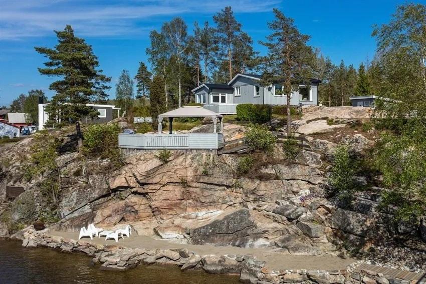 a house on top of a hill next to the water at Beachfront cottage with sea view in Dillingøy