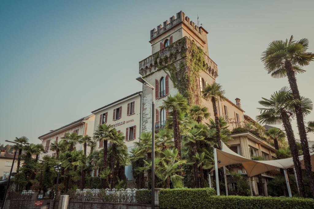 un bâtiment avec des palmiers en face de celui-ci dans l'établissement Romantik Hotel Castello Seeschloss, à Ascona