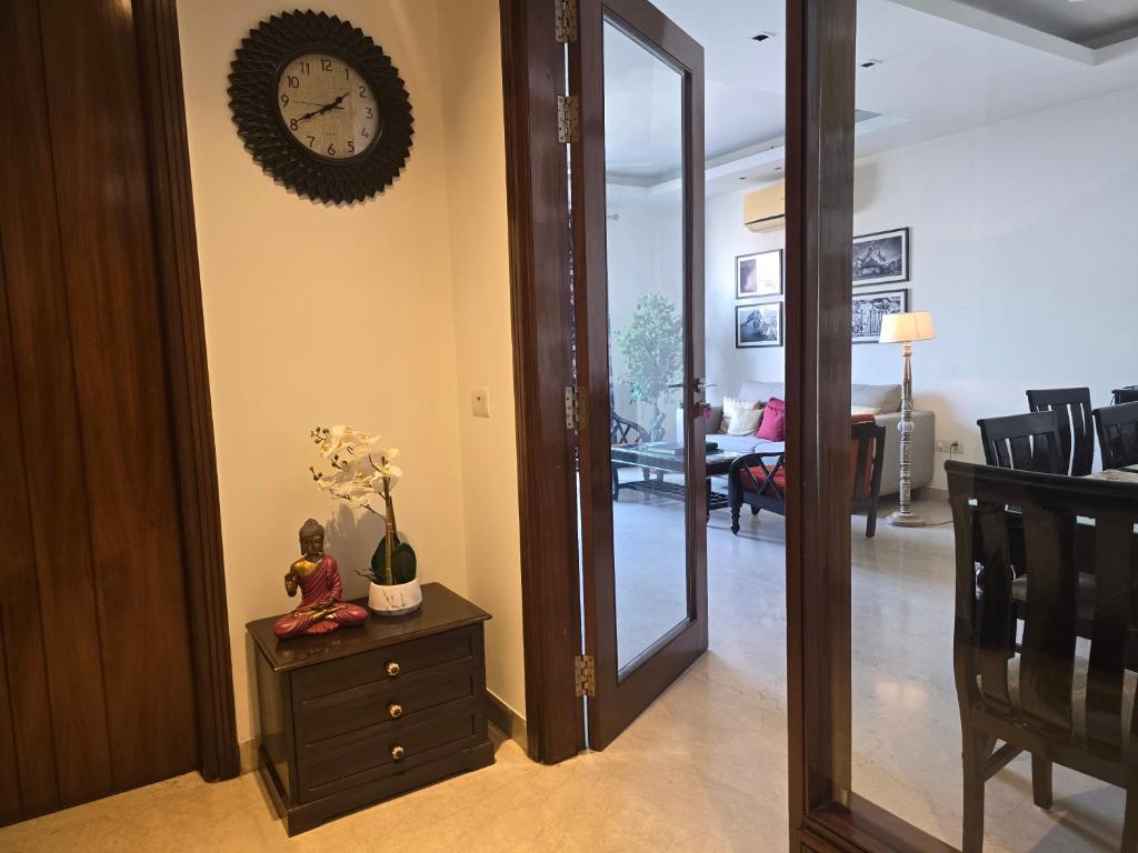 a hallway with a mirror and a clock on the wall at Two Green Park in New Delhi