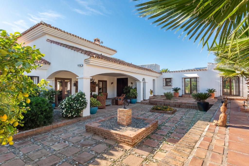 a large white house with a courtyard and trees at Gorgeous Spanish Chalet, Pool and Views in Málaga