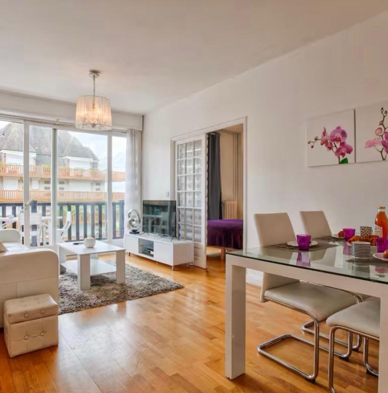 un salon avec une table, des chaises et un canapé dans l'établissement Urban Lodge YourHostHelper, à Deauville