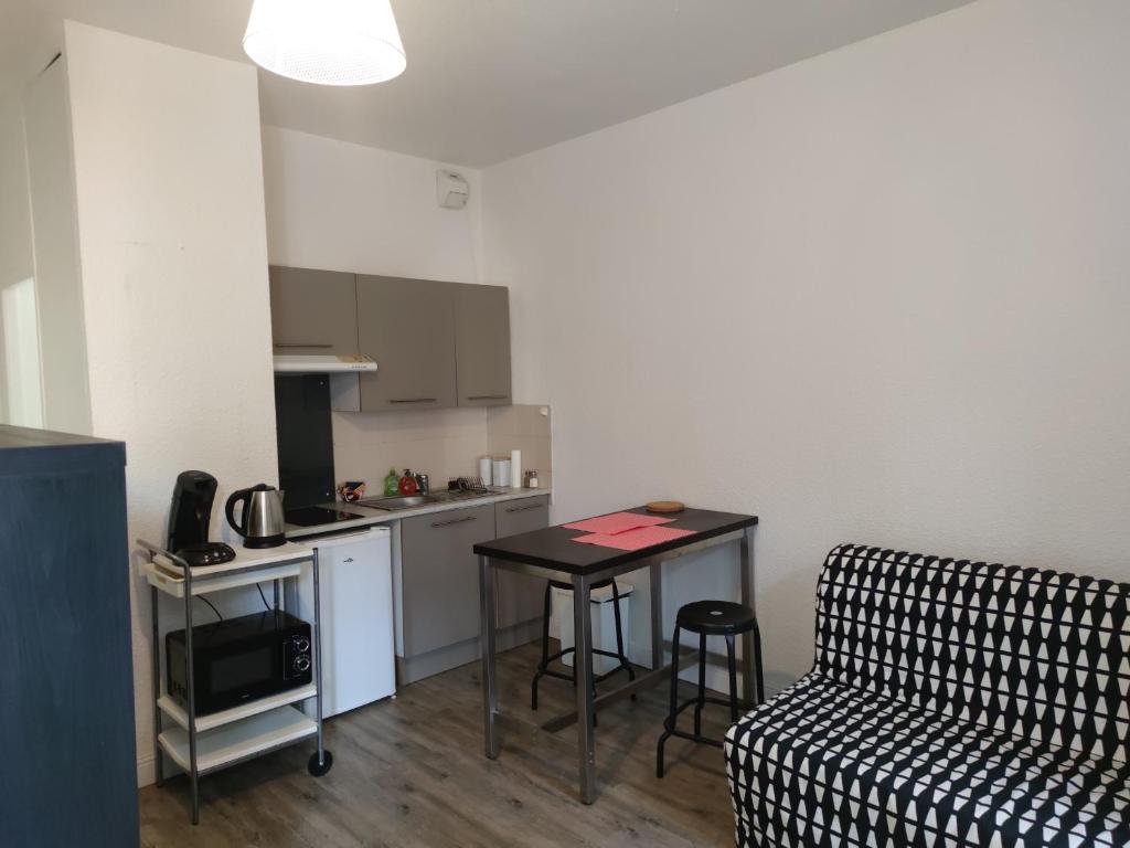 - une cuisine avec un canapé et une table dans une chambre dans l'établissement Le Roosevelt - Central - Park view, Wifi, à Clermont-Ferrand