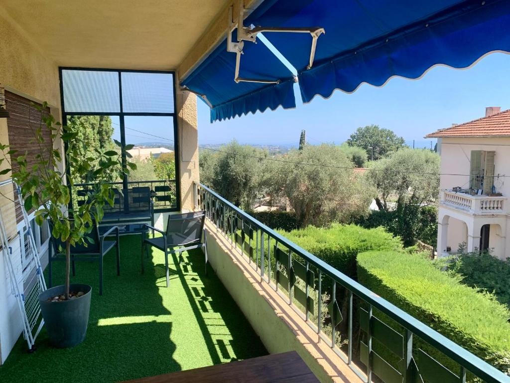 d'un balcon avec une table et une vue sur le jardin. dans l'établissement Vence T3 vue mer grande terrasse, à Vence
