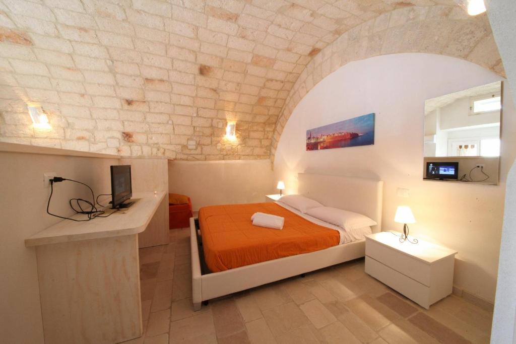 a bedroom with a bed with an orange bedspread at Il Porto Di Ciccia' in Monopoli