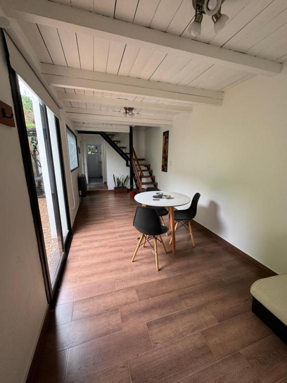 a room with a table and chairs and a staircase at Casi en Casa 2 in Lincoln